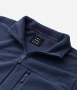 Buzo de hombre confeccionado en tejido fleece con felpa, de corte recto y cuello alto. Cuenta con cierre frontal completo, bolsillos laterales y un bolsillo adicional con cierre en el pecho.
