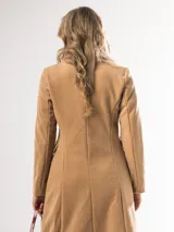 Tapado largo color beige, de corte recto y manga larga.