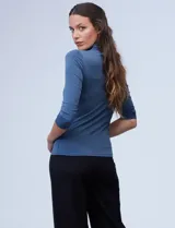 Polera negra de cuello alto y mangas 3/4, confeccionada en tejido elastizado.