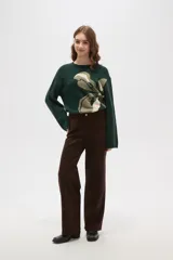 Pantalon de corte recto y tiro medio, confeccionado en tejido de poliester con acabado mate. Presenta bolsillos laterales y cierre frontal con botón metálico.