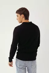 Sweater de punto estilo polo, color negro, con cuello camisero, cierre frontal de botones y mangas largas con puños acanalados. Presenta un pequeño logo bordado en el pecho.