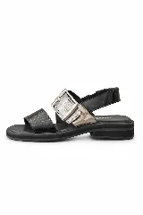 Sandalias de cuero marrón, con diseño de dos fajas amplias, una lisa en la parte delantera y otra superior con hebilla metálica grande y ajustable. Suela plana con plataforma baja y pespunte visible.