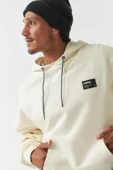 Canguro color crema con capucha ajustable, lettering estampado en el frente, logo en grifa de goma y puños.