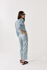 Pantalón de lino metalizado con estampado floral, tiro medio, piernas rectas y bolsillos laterales.