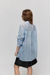 Camisa de rayas de calce relajado, confeccionada en tejido liviano y semitransparente, con cuello clásico, cierre frontal con botones, mangas largas con puños y hombros caídos.