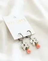 Aros colgantes plateados con cierre de aro, adornados con cristales transparentes y una perla rosa.