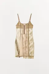 Vestido corto semitransparente tipo corsetero color beige, confeccionado con encaje y detalles de varillas interiores que estilizan la figura. Presenta escote redondo, tirantes finos ajustables y bajo asimétrico con una lazada lateral de satén.