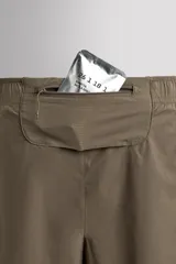Pantalones cortos de running confeccionados en tejido técnico ligero y elástico, con malla interior. Presentan cintura elástica ajustable con cordón, bolsillo trasero con cierre y aberturas laterales en el bajo.