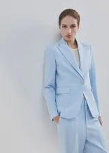 Pantalón de traje color celeste de tiro medio y diseño recto, con bolsillos laterales y cierre oculto.