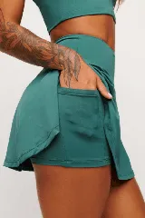 Pollera short deportiva color verde esmeralda, con short interno con bolsillos laterales.