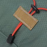 Mochila de senderismo Caterpillar modelo Himalayas Hiking Bac, color verde eucalipto, confeccionada en tejido ripstop de poliéster hexagonal antidesgarro. Presenta cordón elástico delantero de color naranja para almacenamiento adicional, ribetes en color marrón claro y bolsillo lateral de malla negra. Incluye parche de Hypalon en la parte delantera y etiqueta tejida con el logo "Urban Mountain".