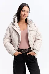 Campera puffer negra con diseño matelaseado en rombos, capucha integrada, cierre frontal y puños elásticos.