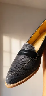 Mocasines de cuero plateado con acabado texturado, diseño clásico con costuras visibles y vira de suela natural cosida. Cuenta con taco plano de 2 cm y plantilla anatómica.
