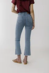 Jean de corte cropped y tiro alto, en color azul oscuro. Presenta un diseño de pierna ligeramente acampanada con ruedo deshilachado.