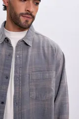 Sobrecamisa de franela a cuadros en tonos de azul y rosado, con mangas largas, bolsillos en el pecho y cierre frontal con botones.