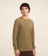 Remera de manga larga de corte regular, confeccionada en tejido waffle de algodón y poliéster en color verde militar, con cuello redondo y puños acanalados.