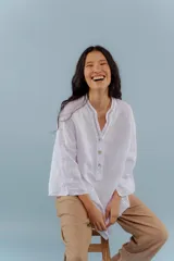 Camisa blanca de lino con escote en V y bordado multicolor.