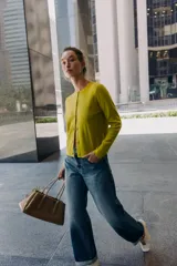 Chaqueta de punto color azul marino, con cuello redondo, manga larga y cierre frontal con botones. Los acabados son en rib a tono.