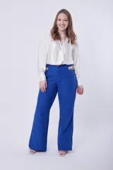 Pantalón palazo azul con detalle de cadena dorada en la cintura.