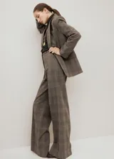 Blazer de corte sastrero con diseño a cuadros, confeccionado en una mezcla de lana, poliéster, viscosa y elastano. Presenta solapas clásicas, cierre frontal con un botón y bolsillos laterales con solapa.