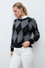 Sweater de punto con diseño de rombos en tonos negro y gris, de cuello redondo y manga larga con puños acanalados.