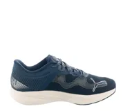 Championes deportivos Puma modelo Redeem Profoam, color azul marino con suela blanca y logo Puma en tono rosado. Presentan una estructura de malla transpirable y refuerzos sintéticos, diseñados para ofrecer amortiguación y soporte.