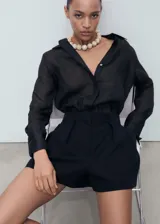 Short negro de tiro medio, corte recto con pinzas delanteras y diseño clásico.