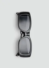Lentes de sol con armazón rectangular de policarbonato negro y cristales oscuros.