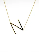 Collar plateado con dije de la letra G mayúscula.