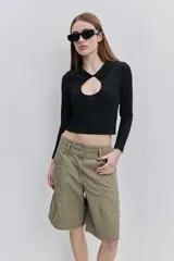 Top de calce al cuerpo color negro, confeccionado en tejido elástico con textura acanalada, con cuello camisero, mangas largas y recorte frontal tipo cut-out.