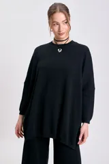 Buzo de punto de corte oversize en color negro, con cuello redondo y mangas largas con puños ajustados.