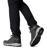 Bota de trekking Columbia modelo Newton Ridge, color gris oscuro con detalles en negro y cordones con toques naranjas. Presenta empeine de ante impermeable, herrajes metálicos y suela de caucho de alta tracción.