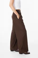 Pantalón sastrero de corte recto y fit relajado, con cintura alta, cierre frontal con botón y bolsillos laterales. Presenta una caída fluida y elegante.