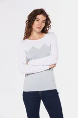 Buzo de tejido de punto con diseño bicolor, combinando blanco en la parte superior y mangas con un tono celeste grisáceo en el cuerpo, presentando un patrón geométrico en la unión de los colores. Posee cuello redondo y mangas largas.