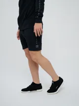 Bermuda deportiva Umbro modelo Terrace, color negro, con bolsillos laterales y detalles sutiles en el lateral.