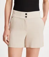 Bermuda roja de poliéster con cintura elástica, bolsillos laterales y cierre con cremallera y botones.