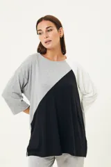 Remerón de manga tres cuartos con diseño de bloques de color en diagonal: gris claro en la parte superior izquierda, negro en la parte inferior derecha y blanco en la manga derecha. Posee cuello redondo y calce holgado.