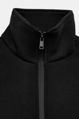 Chaqueta entallada negra de cuello subido y manga larga con hombreras. Cuenta con cierre frontal con cremallera termosellada.