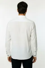 Camisa de poliéster color marrón, de corte holgado, con mangas largas, cuello camisero clásico y cierre frontal de botones.