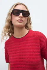 Remera de punto color rojo con mangas cortas, cuello redondo y finos ribetes oscuros en el cuello y puños.