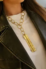 Collar dorado con cadena de eslabones ovalados y dije colgante rectangular con perforaciones.