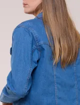 Campera de jean blanca de corte clásico, con cuello solapa, cierre frontal de botones metálicos y bolsillos aplicados con solapa en el pecho.