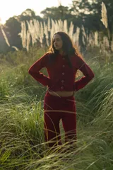 Conjunto de dos piezas color borgoña de tejido acanalado, compuesto por un cárdigan corto con botones y mangas largas con aberturas, y un pantalón palazzo de tiro alto.