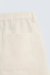 Bermuda de algodón color blanco, de corte relajado, con cintura elástica, bolsillos frontales y bolsillos traseros de plastrón. Cierre frontal con cremallera y botón.