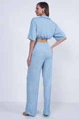 Camisa celeste de tejido con textura, corte cropped, cuello camisero y mangas cortas.