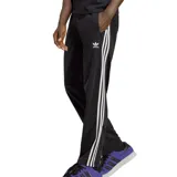 Pantalón deportivo Adidas Adicolor Classics Firebird, color negro con tres rayas blancas a los costados y logo bordado en blanco.