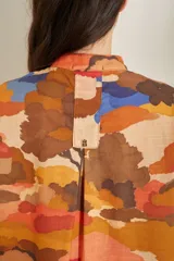 Vestido corto de lino blanco con estampado artístico de paisaje costero, cuello mao y mangas cortas holgadas.