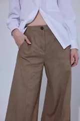 Pantalón de tiro medio y piernas anchas, confeccionado en mezcla de lino y algodón, con bolsillos delanteros y traseros con detalles de costuras pespunteadas a contratono.