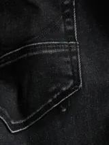 Bermuda de jean color gris oscuro con efecto lavado, de corte recto y largo hasta las rodillas, con dobladillo vuelto en los puños y bolsillos clásicos.