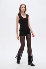 Pantalón de poliamida negro translúcido, de tiro bajo y ajuste ceñido al cuerpo con diseño acampanado en las pantorrillas.